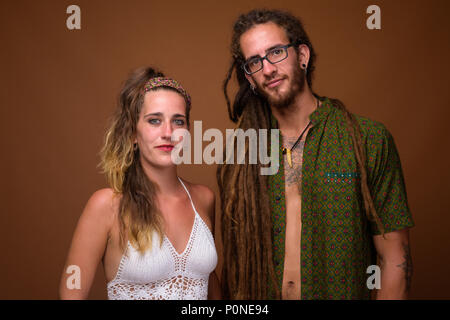 Young Hispanic couple ensemble contre fond brun Banque D'Images