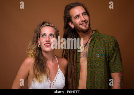 Young Hispanic couple ensemble contre fond brun Banque D'Images