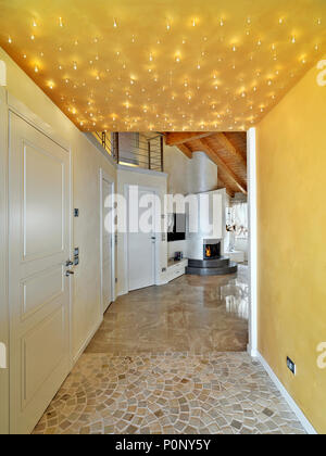 L'entrée moderne de chambre mansardée donnant sur le salon à l'avant-plan la cheminée le plancher est fait de carreaux de pierre Banque D'Images