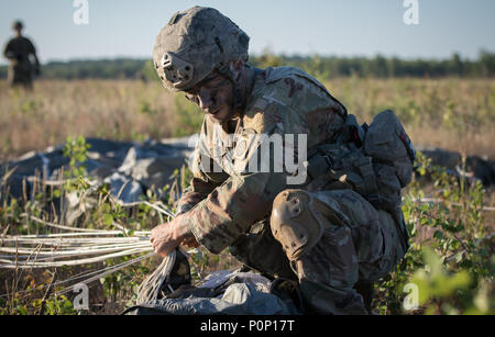 La CPS. Sean Shelts, un parachutiste affecté à l'armée américaine 1er Bataillon, 508e Régiment d'infanterie, 3e Brigade Combat Team, 82e Division aéroportée, packs son parachute et recueille son matériel après avoir sauté d'un avion près de Rukla, Lituanie, dans le cadre de réponse rapide 18 9 Juin, 2018. Réponse rapide 18 est une formation multinationale exercice visant à maintenir l'état de préparation et la cohésion des unités participantes de plusieurs pays. La 82e Division aéroportée a commencé la mission à sa station d'accueil de Fort Bragg, N.C., la réalisation d'un non-stop vol transcontinental qui présentait un ravitaillement en vol Banque D'Images