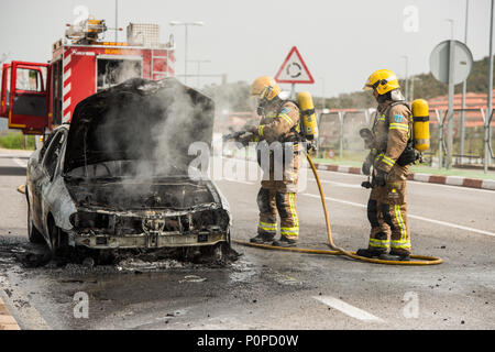 Les pompiers éteindre une voiture qui a brûlé dans une rue de Barcelone. Banque D'Images