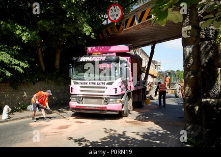 Skip to camion coincé sous un pont faible Lancaster Lancashire England UK Banque D'Images