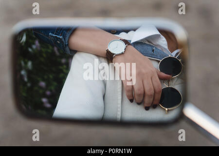 Rétroviseur close-up. Woman's hand avec watch se trouve sur l'épaule de l'homme. Lunettes de soleil. Couple sur un voyage. Banque D'Images