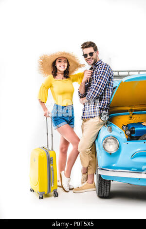 Cheerful young travelers avec assurance l'article en voiture à ouvrir le capot isolated on white Banque D'Images