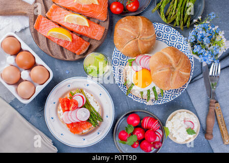 Du pain avec du fromage, l'oeuf et l'asperge, un autre pain avec le saumon et les asperges.. Alimentation saine. Délicieux petit-déjeuner. Fond gris Banque D'Images