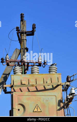 Vieux et obsolètes de transformateur électrique dans le contexte d'un ciel bleu. Dispositif pour la distribution de fourniture de l'énergie à haute tension Banque D'Images