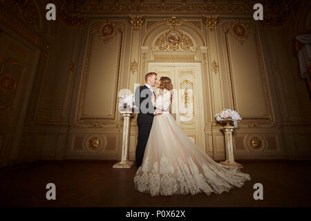 Wedding couple charmant à l'intérieur de style baroque se serrant les uns les autres sur le grand palais royal Banque D'Images