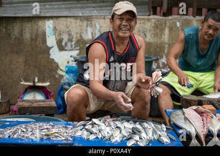 Un homme sourit à la vente du poisson pour le marché du carbone,appareil photo,Cebu City,Philippines Banque D'Images