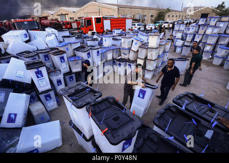 Bagdad, Iraq. 10 Juin, 2018. Les gens se déplacent les urnes que la fumée s'élève à partir d'un incendie qui éclate à Bagdad des boîtes de scrutin le plus grand entrepôt à Bagdad, Iraq, 10 juin 2018. L'assemblée a voté mercredi en faveur d'un recomptage des bulletins de manuel au milieu d'allégations de fraude. Ameer Al Mohammedaw : Crédit/dpa/Alamy Live News Banque D'Images