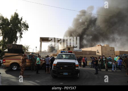 Bagdad, Iraq. 10 Juin, 2018. Les forces de sécurité irakiennes et les pompiers rassembler comme des ondes de fumée dans des entrepôts à Bagdad, l'Iraq, le 10 juin 2018. Un violent incendie a éclaté dimanche dans trois entrepôts contenant des boîtes de scrutin de l'élection parlementaire au centre-ville de capitale Bagdad. Credit : Khalil Dawood/Xinhua/Alamy Live News Banque D'Images