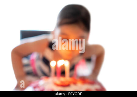 Abstract image floue de trois ans girl blowing out candles pour anniversaire. Une image d'enfant blowing out birthday candles on white background Banque D'Images