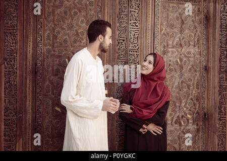 Les jeunes couples musulmans par rapport à parler et souriant dans un style arabe température Banque D'Images