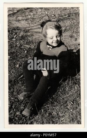 HODONIN, la République tchécoslovaque, vers 1941 : Vintage photo montre une petite fille est assise sur l'herbe, vers 1941 Banque D'Images