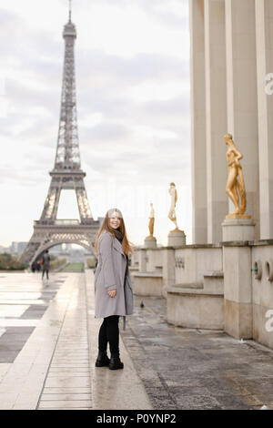 Caucasian woman standing on Trocadero square près de statues dorées et Tour Eiffel. Banque D'Images