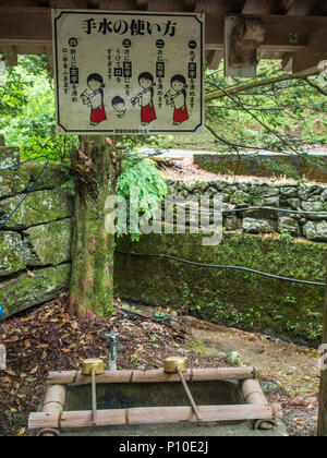 Temizuya, fontaine à eau, avec carte d'instructions, pour la purification de l'eau, rituel effectué avant d'entrer dans le lieu sacré japonais, Osaki Hachiman shinto Banque D'Images