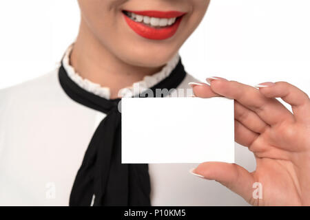 Jeune femme d'affaires avec un sourire parfait et les ongles détient blank business card en gros plan sur un fond blanc. Banque D'Images