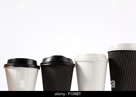 Quatre tasses de café en plastique dans une rangée sur fond blanc avec copie espace Banque D'Images