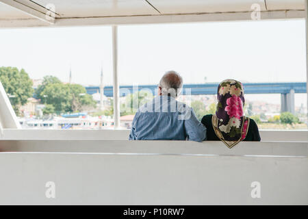 Istanbul, 17 juin 2017 : un couple de résidents locaux, un homme et une femme sont la voile sur un bateau à passagers ou en ferry, regarder la distance et parler. La vie ordinaire en Turquie Banque D'Images