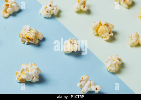 Le pop-corn dans tasse de papier sur fond bleu et vert. Banque D'Images