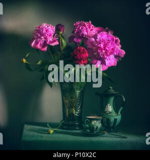Nature morte avec fleurs et une tasse de café. Un bouquet de pivoines. vintage. Banque D'Images