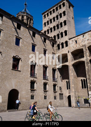 Un groupe de touristes viennent en vélo avec leur guide pour voir le King's Square (Plaça del Rei), une cité médiévale du 14e siècle place publique dans le Barri Gòtic o Banque D'Images