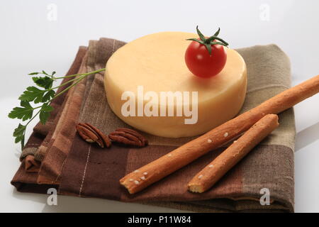Petite meule de fromage à côté de tomates cerises Banque D'Images