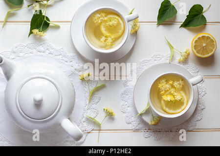 Deux tasses de thé de fines herbes avec des fleurs de tilleul et de citron, vue du dessus Banque D'Images