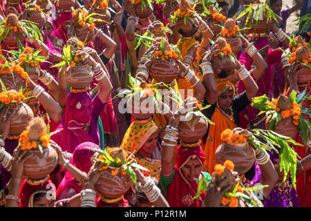 Les femmes indiennes transportant des offrandes sur la tête lors d'un festival du Rajasthan, Pushkar, Inde Banque D'Images