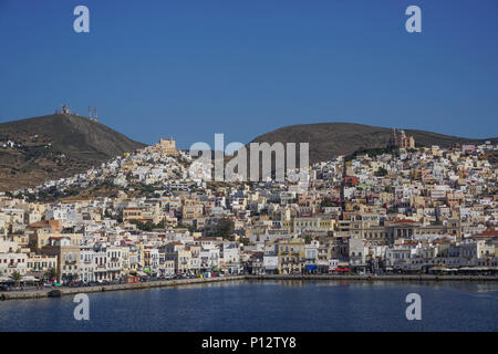 Syros, Grèce : les collines, maisons, églises, boutiques, et le port d'Ano Syros et Hermoupolis brillent au soleil sur l'île égéenne de Syros. Banque D'Images