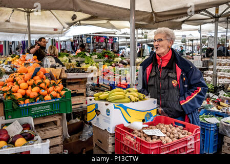 Vieille Femme romaine la vente des produits au Campo de Fiori le marché en plein air à Rome, en Italie, avec des mandarines, des bananes et noix, légumes colorés Banque D'Images