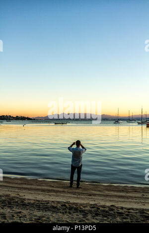 L'homme photographié le paysage à Santo Antonio de Lisboa plage au coucher du soleil. Florianopolis, Santa Catarina, Brésil. Banque D'Images