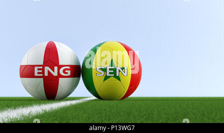 Angleterre vs Sénégal Match de football - ballons de soccer dans Englands et Senegals couleurs nationales sur un terrain de soccer. Copie de l'espace sur le côté droit Banque D'Images