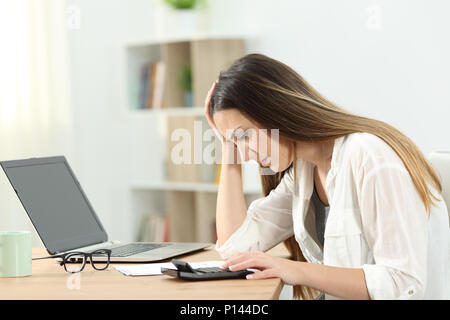 Femme au foyer de faire peur à l'aide d'une comptabilité calculatrice à la maison Banque D'Images