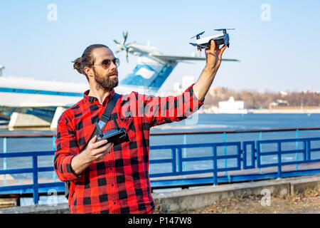 Guy démarre un quadrocopter dans le parc, un fermer Banque D'Images