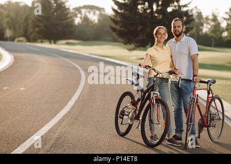 Couple de jeunes cyclistes sur la route. Photo de couple reste avec des vélos. Le repos actif ensemble. Banque D'Images