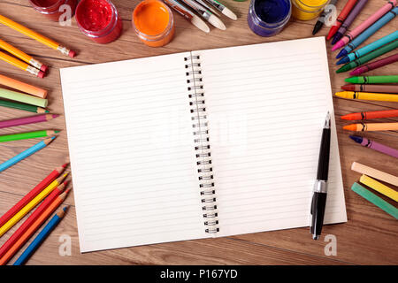L'écriture blanche sur un bureau de l'école avec différentes peintures, crayons et stylos. Banque D'Images