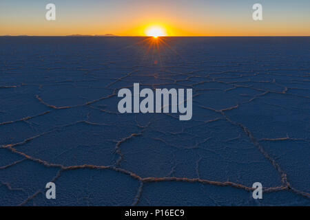Les derniers rayons du soleil qui brille sur le désert de sel dans l'Uyuni salt flat au coucher du soleil dans l'altiplano bolivien (Salar de Uyuni), Bolivie, Amérique du Sud. Banque D'Images