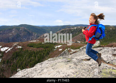 Randonneur fille sautant et admirer la beauté du paysage au sommet du Mont du Lac des cygnes dans le parc national des Grands-Jardins, Québec, Banque D'Images