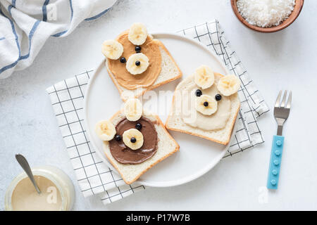 Petit-déjeuner toasts avec beurre de noix et banane avec mignon drôle visage animal. La nourriture pour les enfants, pour les enfants petit déjeuner ou déjeuner à l'école. Vue d'en haut Banque D'Images