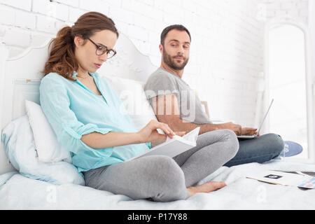 L'accent pregnant woman reading book Banque D'Images