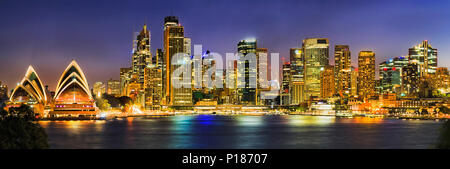 Sur le port de Sydney au bord de rives autour de Circular Quay quai entouré de repères CDB ville au coucher du soleil avec un éclairage lumineux reflétant dans Banque D'Images