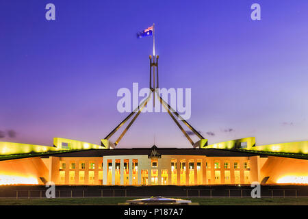 La construction du Parlement sur la colline du Capitole à Canberra - façade, entrée privée et colonnes illuminées avec grand mât et mât sur le toit. Il s'agit d'un publi Banque D'Images