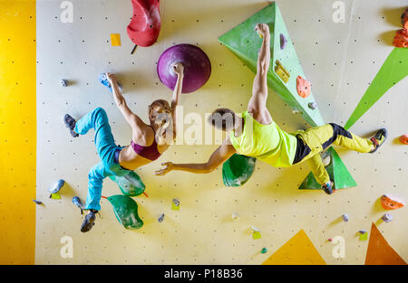 Grimpeurs en escalade. Jeune couple climbing bouldering problèmes (routes), l'homme encourageant girl grimpeur. Banque D'Images