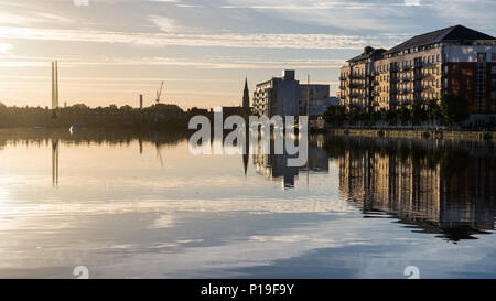 Dublin, Irlande - Septembre 18, 2016 : le monument de Poolbeg cheminées Twin Power Station et édifices à appartements et de bureaux modernes se reflètent dans Banque D'Images