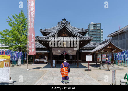 Un pèlerin bouddhiste debout à l'extérieur du Temple d'Daikoku-Dou dans le parc du complexe du Temple Shitennoji, Osaka, Japon Banque D'Images