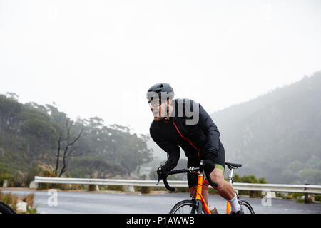 Mise sous tension montée cycliste homme déterminé Banque D'Images