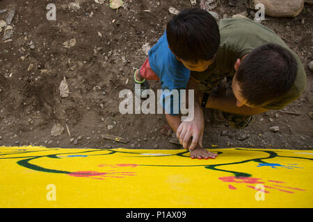 La Marine américaine lance le Cpl. Justin Blecha aide une élève de l'école primaire San Vicente placer sa main pour imprimer sur un mur qui a été restauré au cours de l'exercice d'atterrissage amphibie des Philippines (33) PHIBLEX à Cagayan Valley, Philippines, le 9 octobre 2016. PHIBLEX-américain annuel est un exercice bilatéral militaire des Philippines qui combine les capacités amphibies et de tir réel avec assistance civique humanitaire visant à renforcer l'interopérabilité et les relations de travail. Blecha est un ingénieur de la Compagnie Bravo, 9e Bataillon de soutien du génie, 3d Marine Logistics, Groupe III pour la Force expéditionnaire des marines Banque D'Images