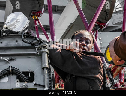 161007-N-WA993-080 MER DES PHILIPPINES (24 oct. 7, 2016) Tyteanna Marin Wallace, de Montgomery, Alabama, attribué à l'Saberhawks "hélicoptère" de grève Maritime Squadron (HSM) 77, utilise un ruban pour fixer laver laver le papier sur l'amortisseur d'un MH-60S Sea Hawk à bord de la Marine a seulement l'avant-déployé, porte-avions USS Ronald Reagan (CVN 76). Se laver et laver les bandes papier sont utilisés pour s'assurer que l'eau ne pénètre pas dans le volet d'aéronefs au cours de laver ses bas. Ronald Reagan, le groupe aéronaval du cinq (5) CSG, phare est en patrouille soutenir la sécurité et la stabilité dans la région du Pacifique-Indo-Asia. (U.S Banque D'Images