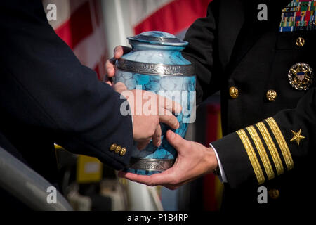 161014-N-ZI635-642 BALTIMORE (oct. 14, 2016) Peter Spiro, fils de l'ancien colonel Michael Spiro, fournit l'urne contenant les cendres de son père pour le Capitaine Scott Tait, directeur général, à bord d'avenir USS Zumwalt (DDG 1000). Le colonel Spiro était le long temps aide de camp de l'Adm. Elmo Zumwalt, le navire homonyme. Zumwalt, le navire de tête d'une classe de la prochaine génération de destroyers à missions multiples conçu pour accroître sa puissance navale de la mer, sera mise en service le 15 octobre à Baltimore. (U.S. Photo de la marine du Maître de 2e classe George M. Bell/libérés) Banque D'Images