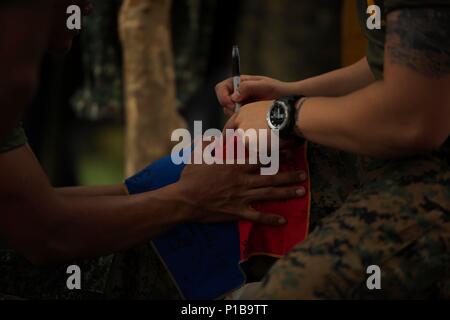 Circuit Marine philippine. Japeth Inocencio, d Jamindan, Philippines, reçoit un drapeau philippin signé par un colonel de la Marine américaine Ernesto Ravina Air Base, aux Philippines, au cours de l'exercice d'atterrissage amphibie des Philippines (33 PHIBLEX), 10 octobre 2016. PHIBLEX-américain annuel est un exercice bilatéral militaire des Philippines qui combine les capacités amphibies et de tir réel avec assistance civique humanitaire visant à renforcer l'interopérabilité et les relations de travail. Inocencio est avec Marine Special Operations Group, Philippine Marine Corps. (U.S. Marine Corps photo par Lance Cpl. Nelson Dueñas/Rel Banque D'Images